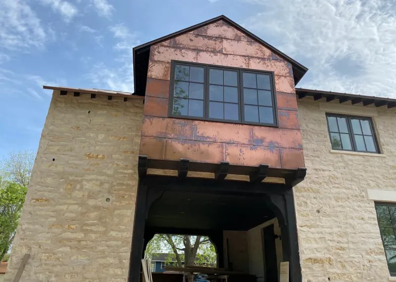 Copper metal panel facade on a stone building for Skylight Installation in Steamboat Springs