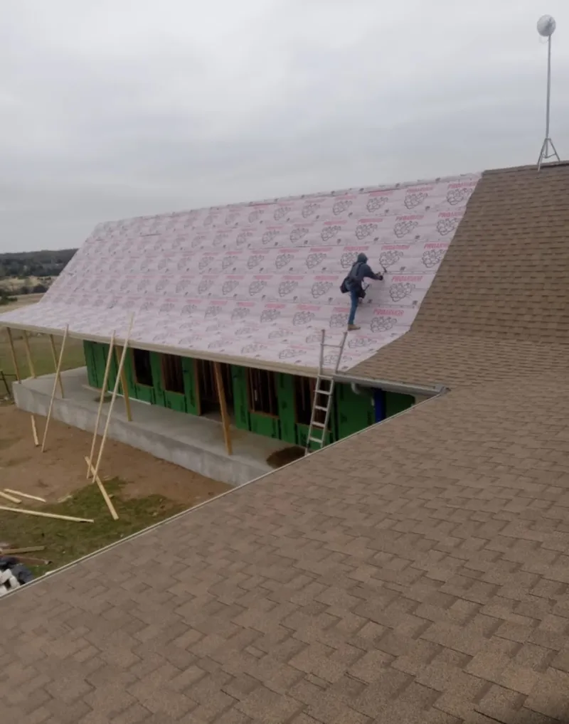 Worker preparing underlayment for a metal roof installation in Steamboat Springs